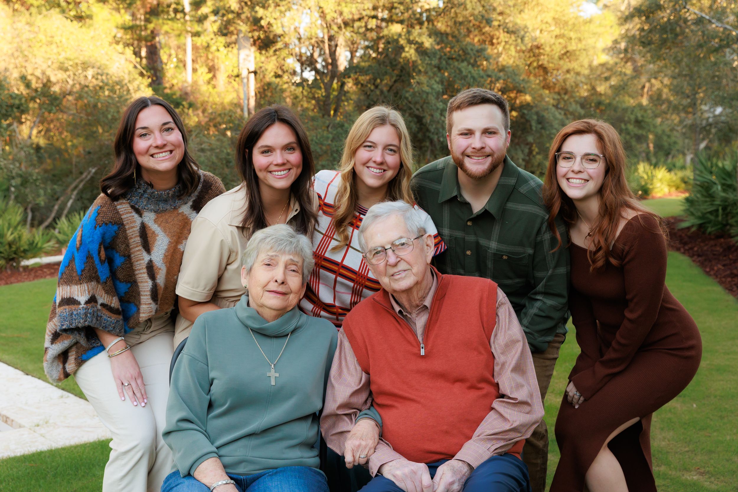 A multi-panel photo collage shows a family gathering outdoors during golden hour in a park setting.