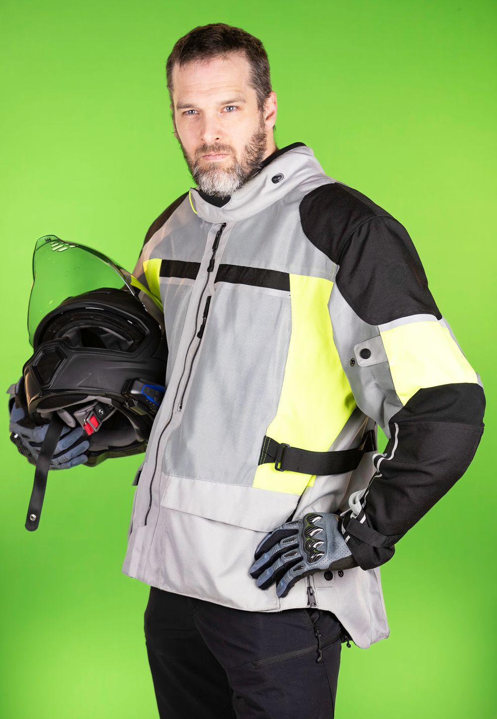 Person in black and gray winter gear demonstrates various poses against green backdrop.