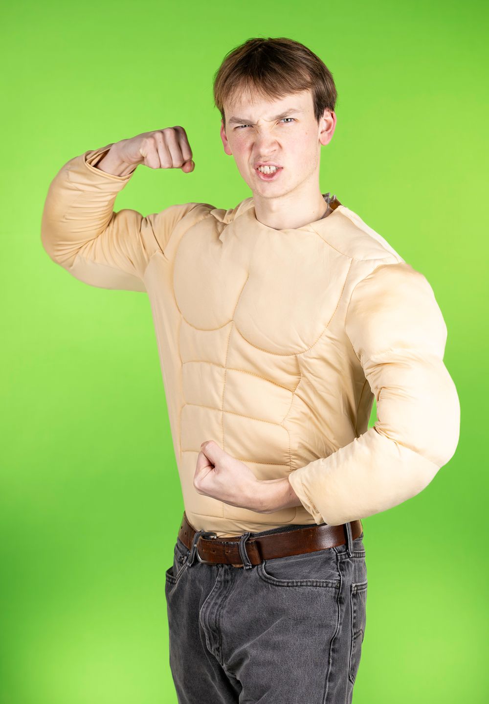 Figure in beige padded suit strikes dynamic poses against green screen.