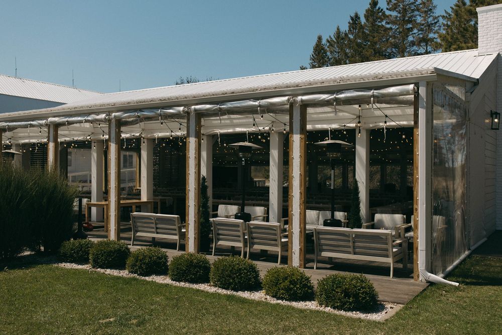 A modern white barn-style event venue with covered outdoor patio areas.