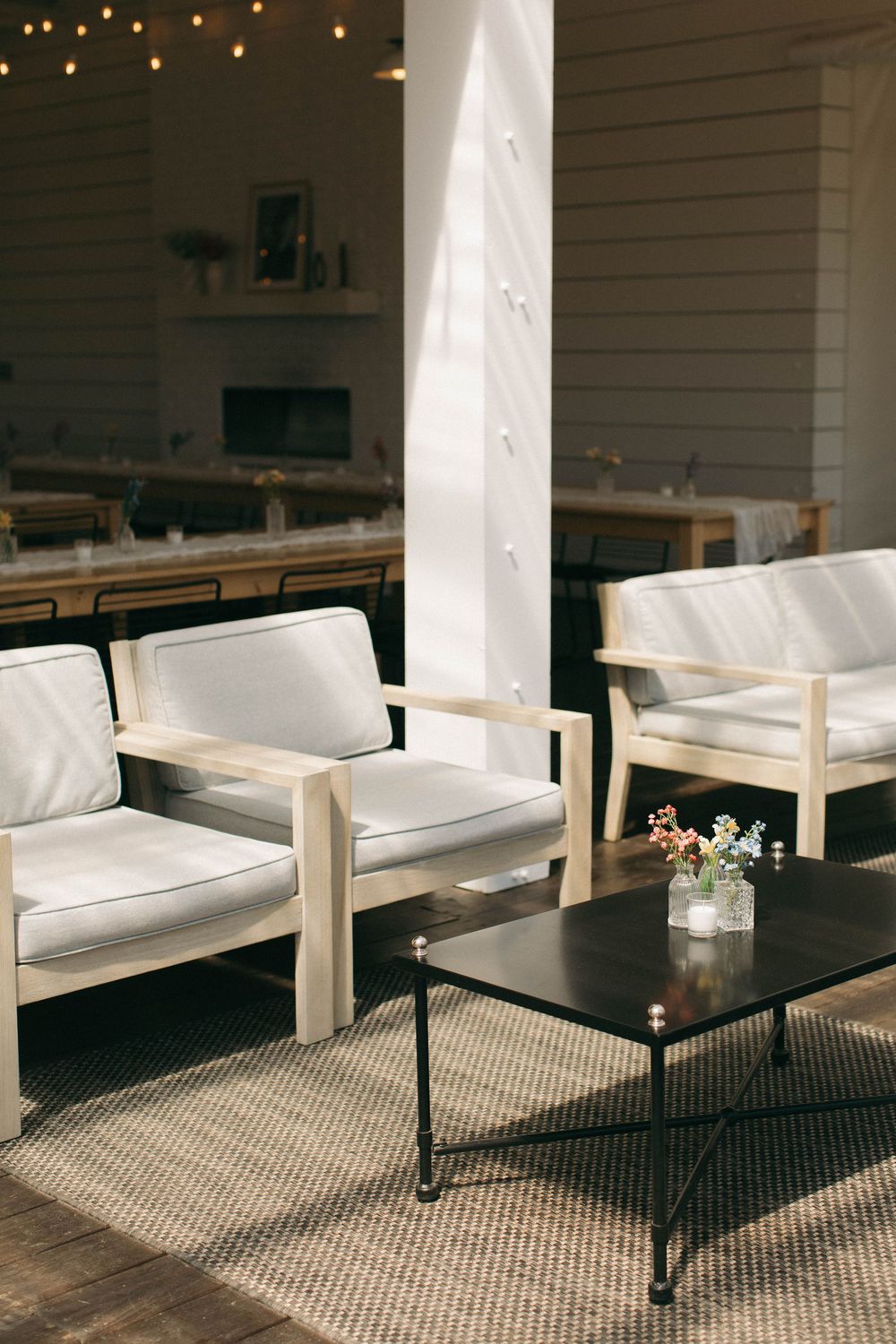 Modern white lounge furniture arranged with black coffee tables in an indoor venue space.