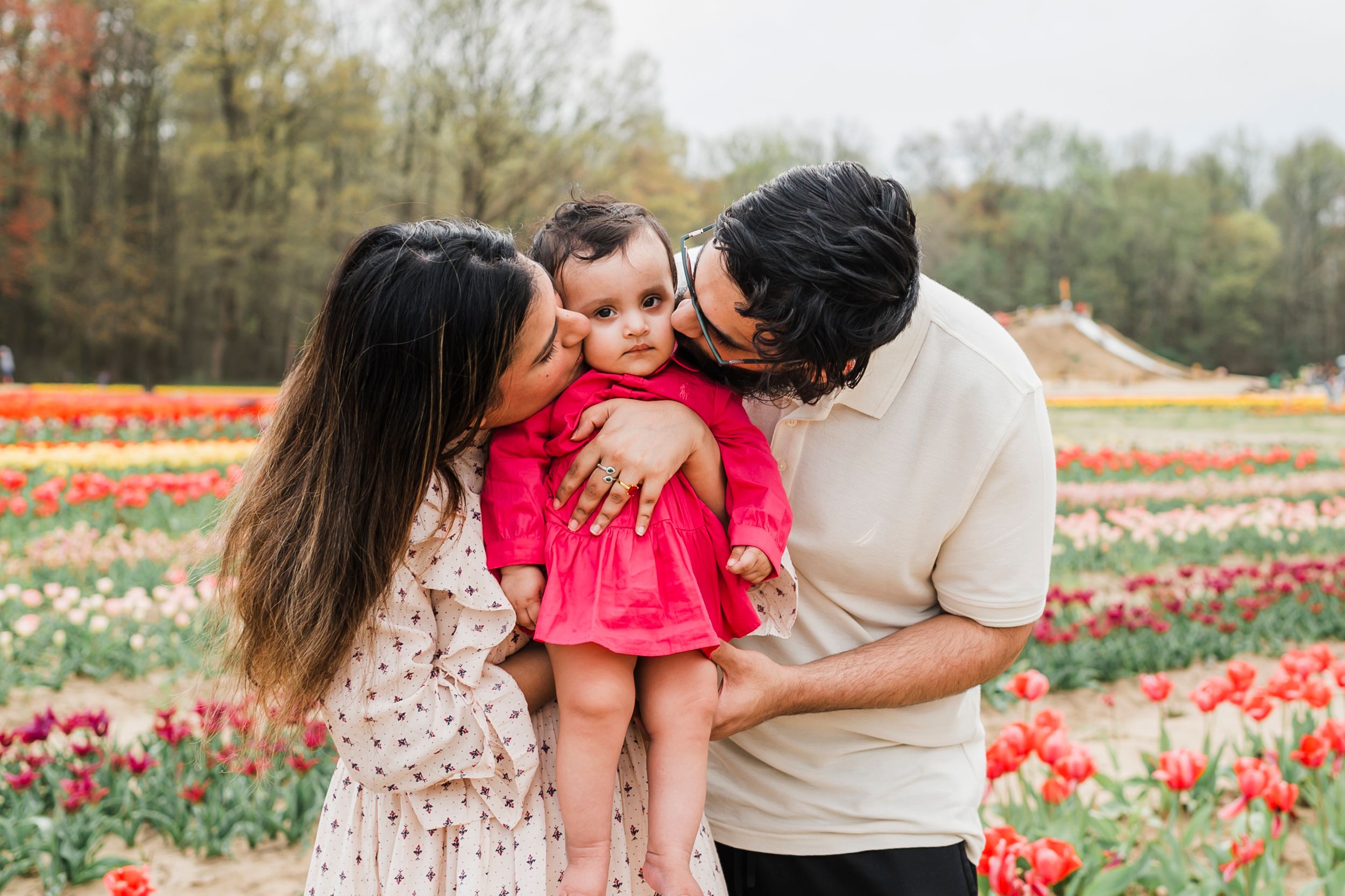Family sharing tender moment together in colorful tulip field during spring season.