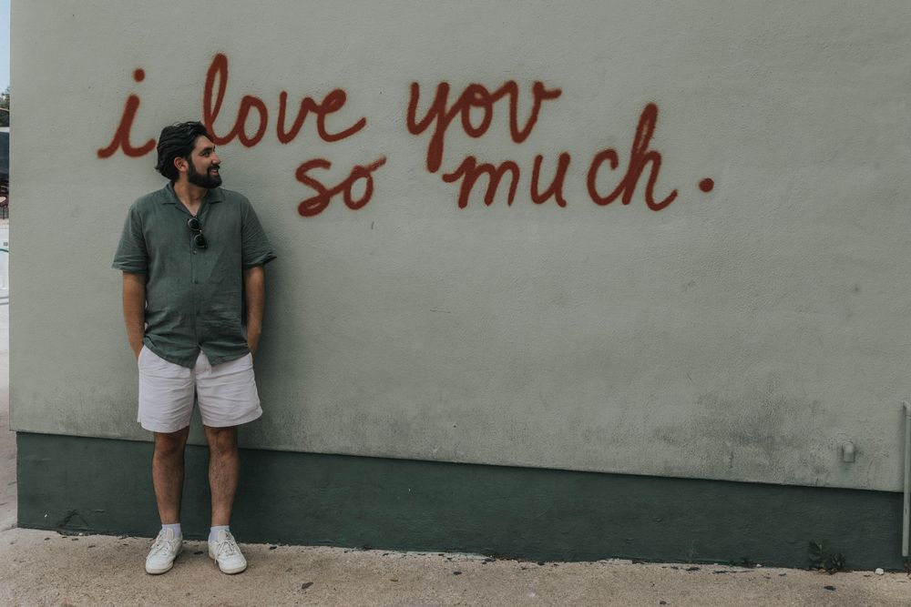 Handwritten text saying 'I love you so much' on a light colored wall.
