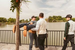 Wedding celebration candid moment on outdoor deck overlooking water.