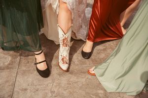 A collection of dress shoes and heels on a tiled floor showing wedding party footwear.