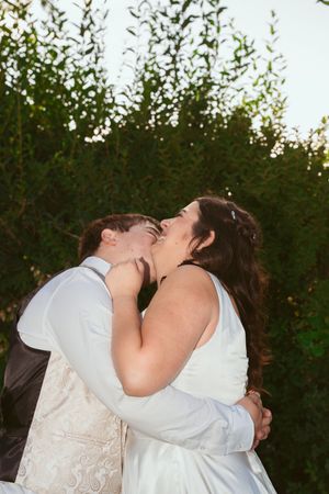 A romantic moment shared between a couple among garden greenery.