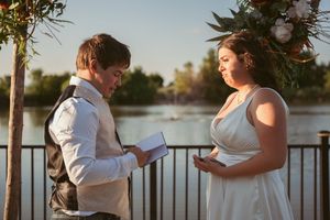 A couple exchanges vows during their outdoor waterfront ceremony.