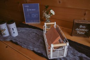 Rustic wooden decor items including white ceramic jar, decorative boxes, and text signage arranged on wooden shelving.
