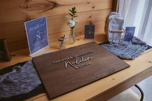 Custom wood signs and decor with rustic finishes arranged on wooden tables in showroom display.