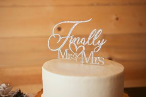 Close up of elegant white calligraphy wedding decor signs on wooden table.