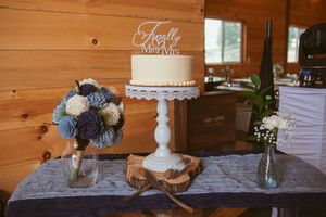 Rustic wooden wall display featuring elegant white cake stands with desserts and decorative elements.