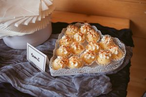 Wedding dessert table displaying homemade pies and treats on vintage-style white cake stands.