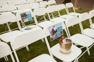 White folding chairs set up for outdoor wedding ceremony with photos and decorative elements.