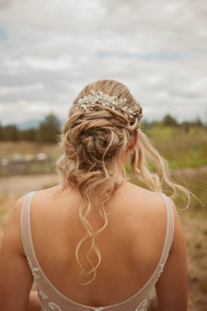 Elegant bridal hairstyle featuring an updo with loose curls and crystal hair accessory.