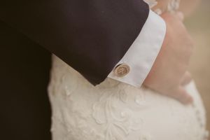 Detailed shot of groom's cufflink on white dress shirt sleeve.