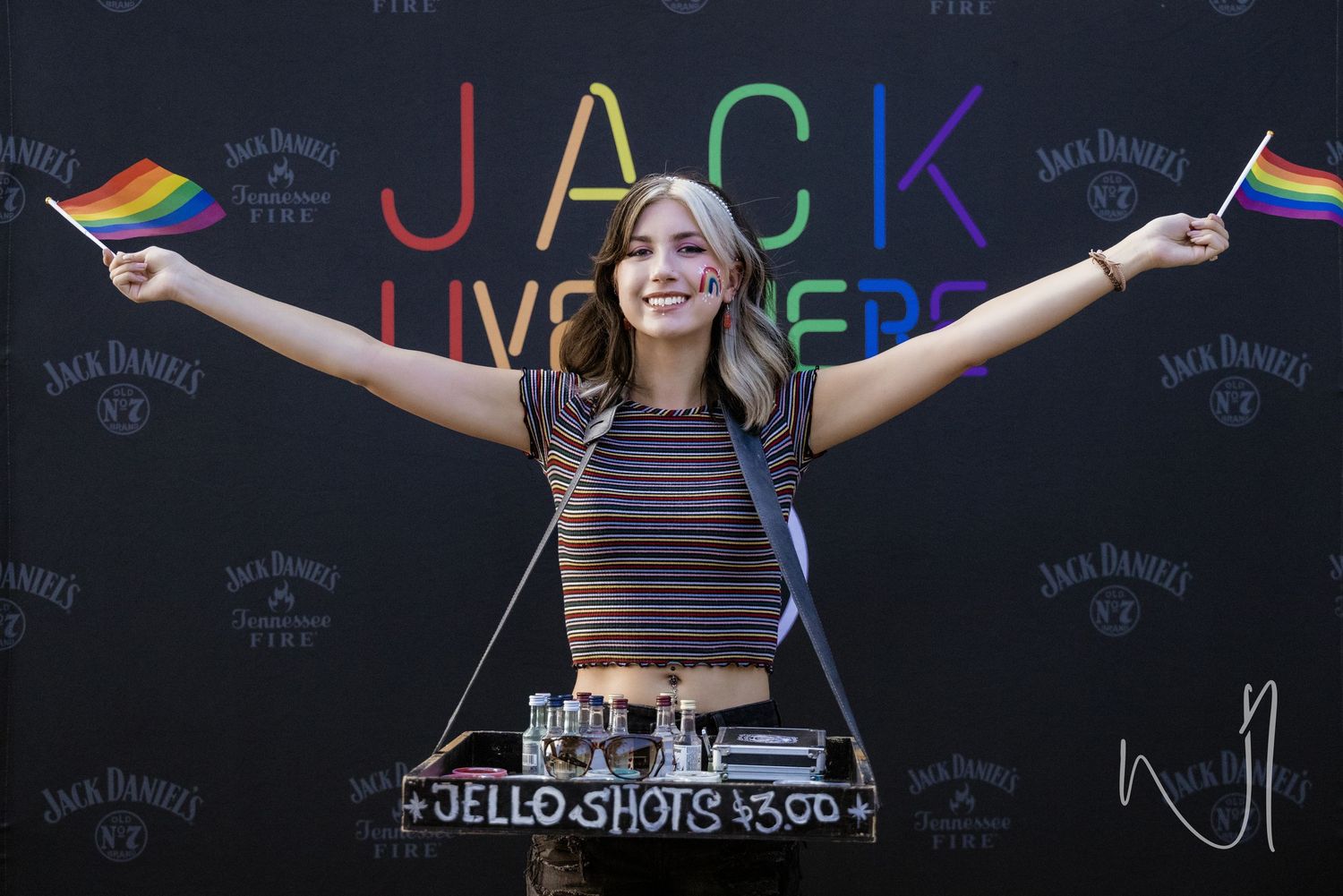 A DJ performs at an outdoor event in front of a Jack Daniel's branded backdrop.
