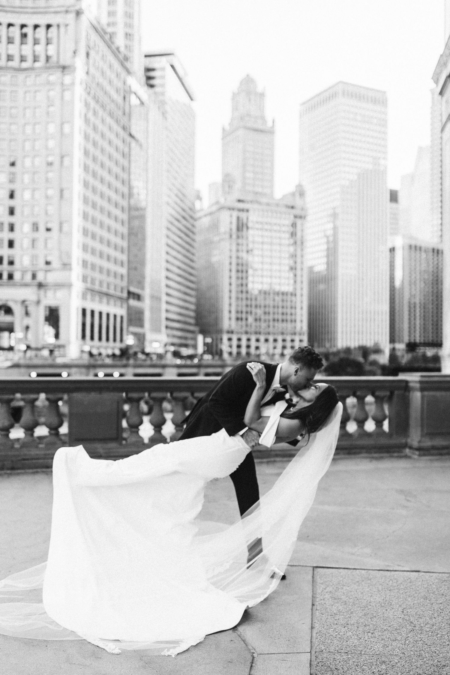 Black and white cityscape wedding photos with flowing dress against Chicago skyline.