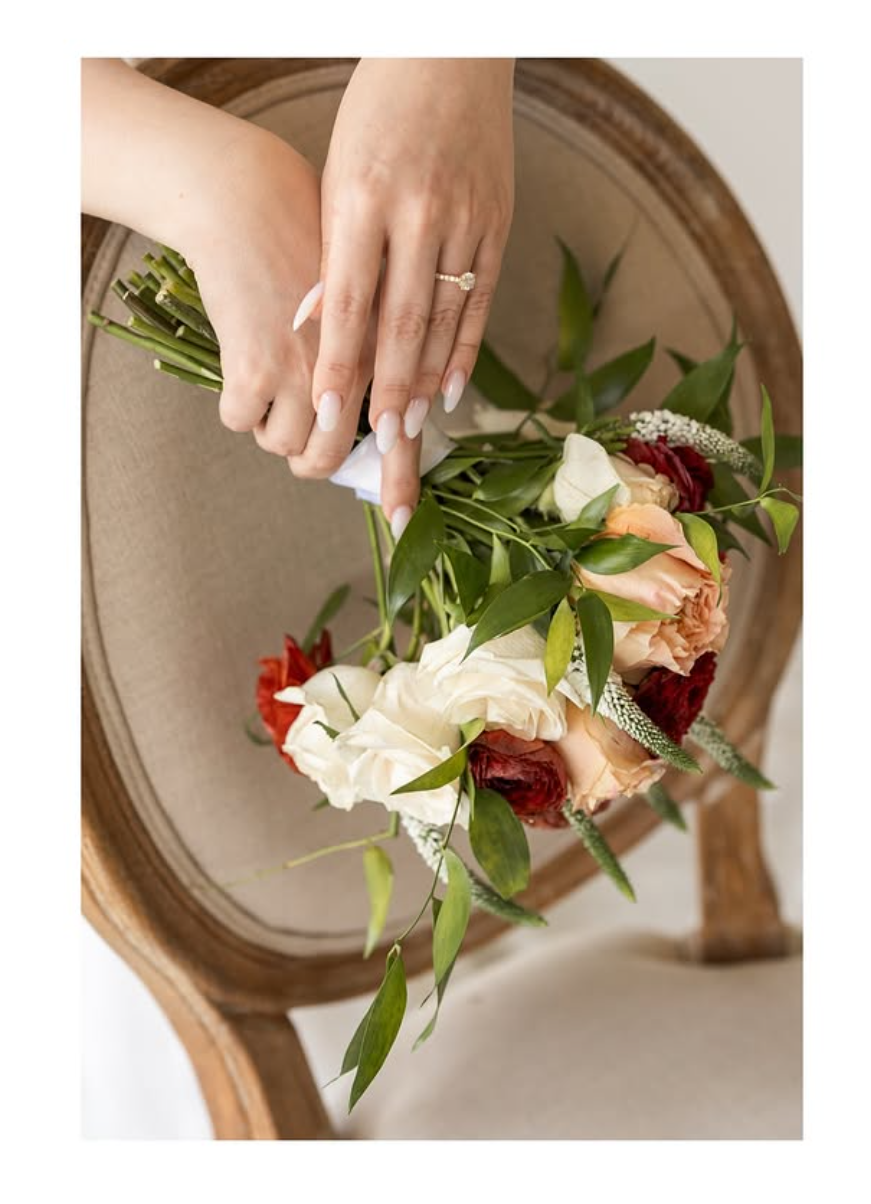 A beauty professional in a white shirt works on styling an elegant updo with delicate hair accessories.
