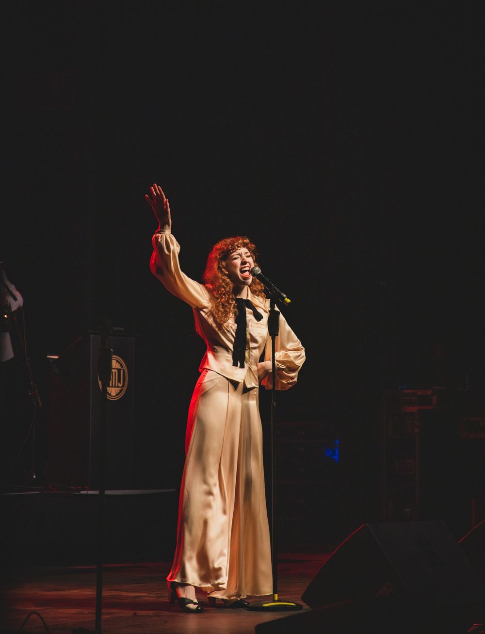 Four consecutive stages show a performer in white robes gesturing dramatically on a darkly lit stage with dramatic lighting.