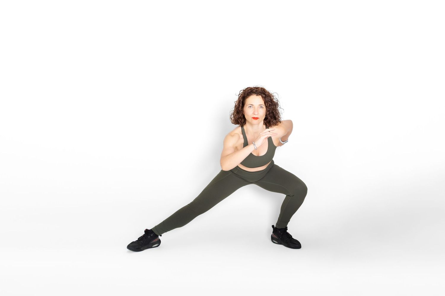 A dancer in black and lace performs an expressive three-part movement sequence on a white background.