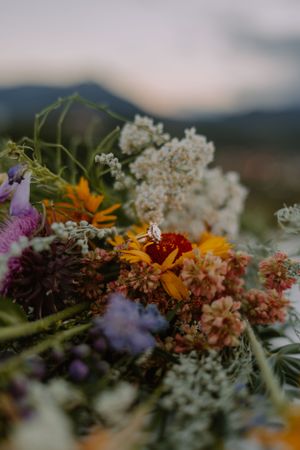 Closeup of marquise cut engagement ring on a colorful wildflower bouquet.