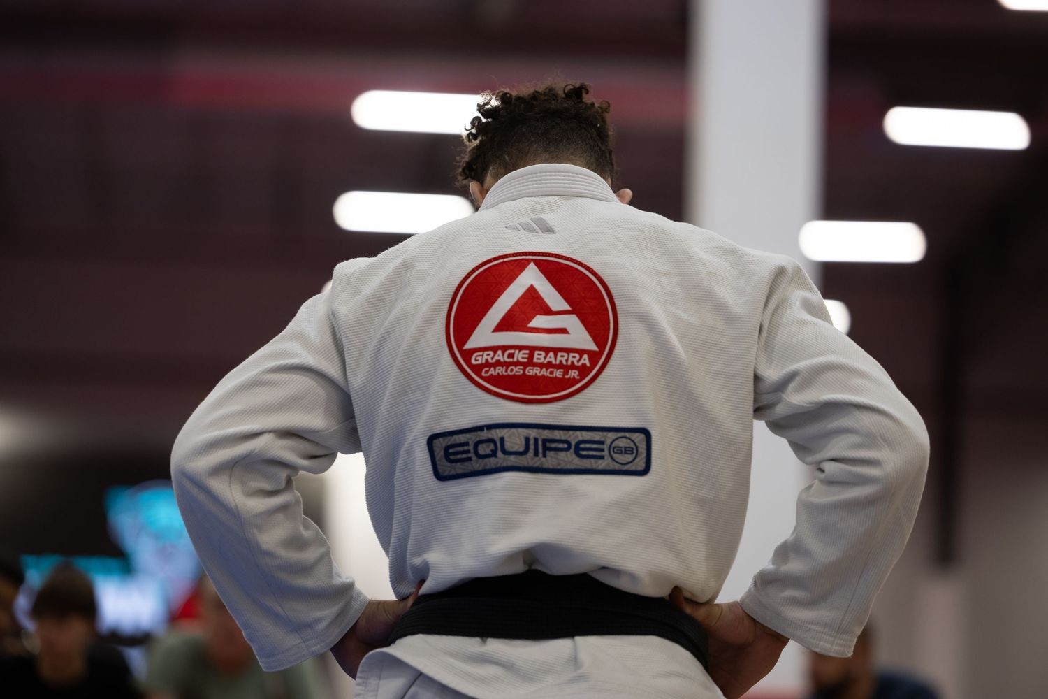 Martial artists wearing traditional gis compete in a grappling tournament.