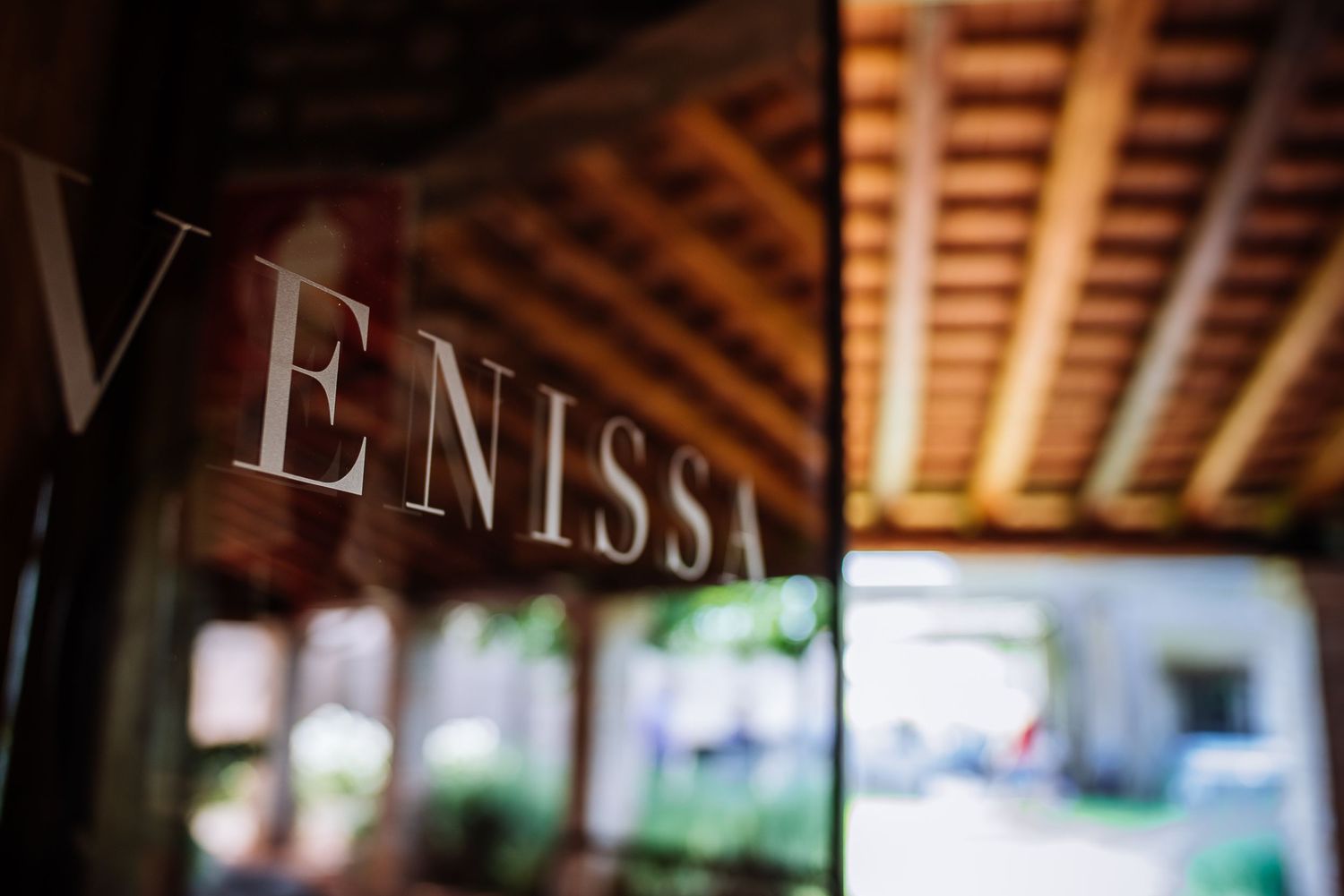 Shallow focus shot of Venissa sign with wooden beams visible in background.