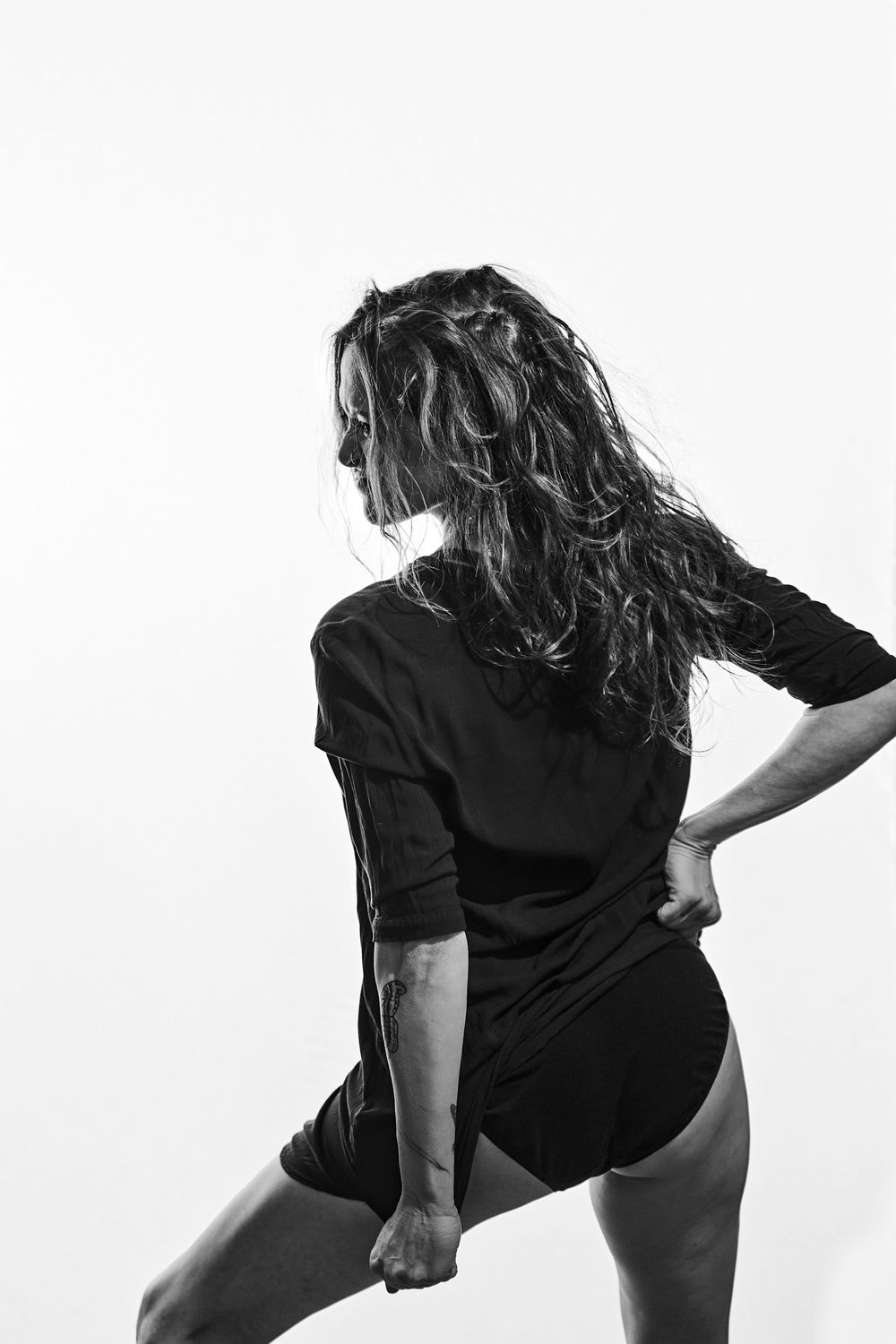Black and white sequence showing contemporary dance movements in contrasted silhouettes against white background.