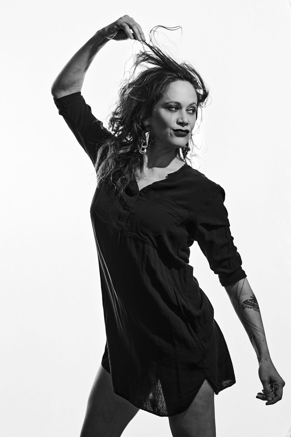 A sequence of dynamic dance movements captured in black and white showing a performer in flowing black attire.