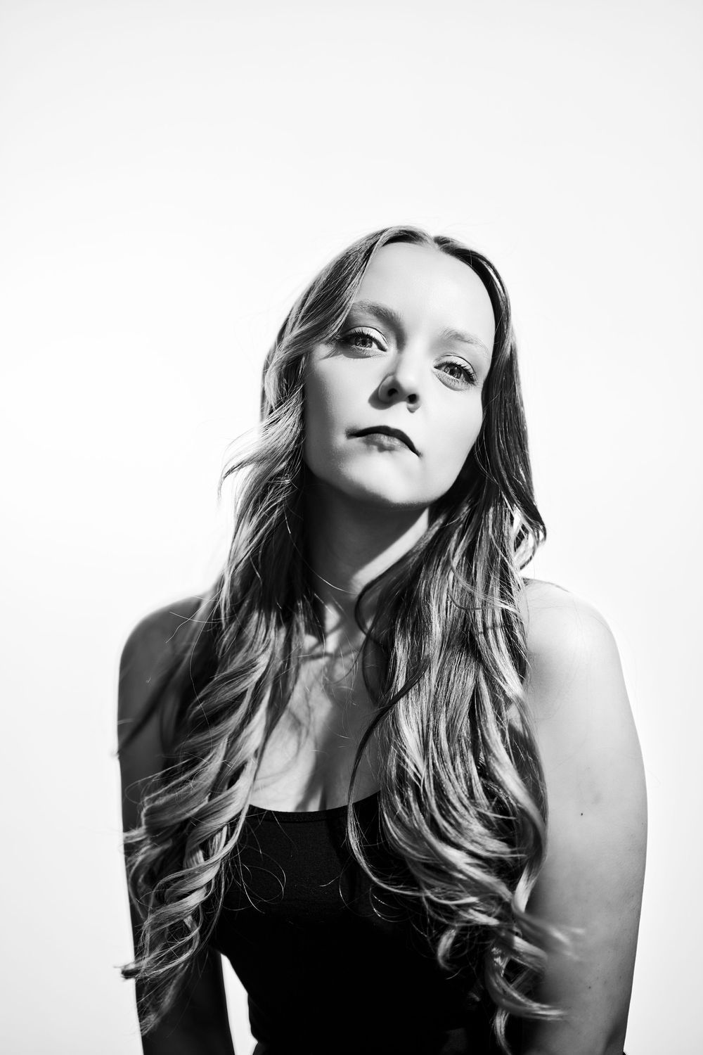 Artistic black and white portrait series showing dramatic poses with flowing hair against white background.