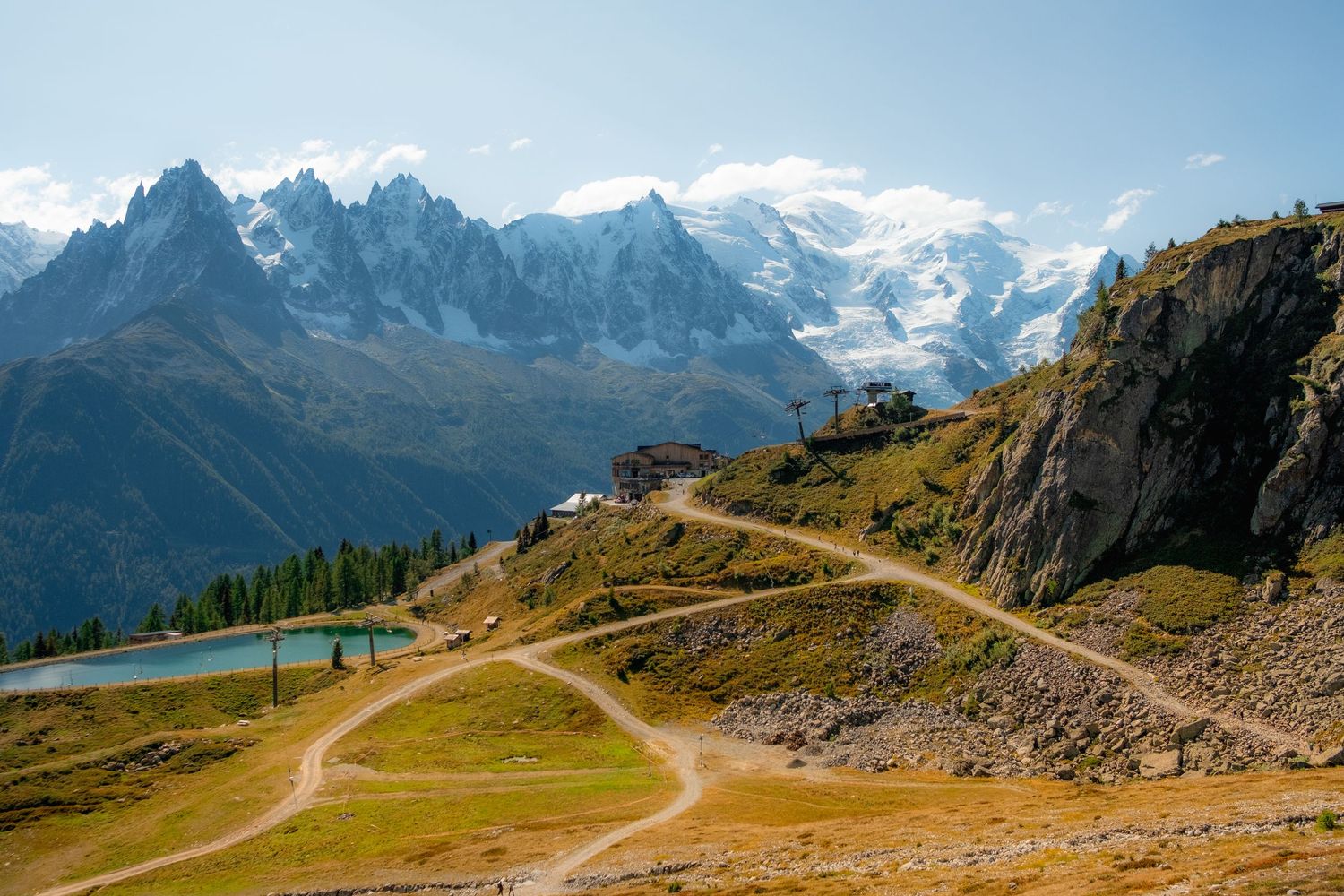 Winding mountain trail with panoramic views of snow-capped Alpine peaks.