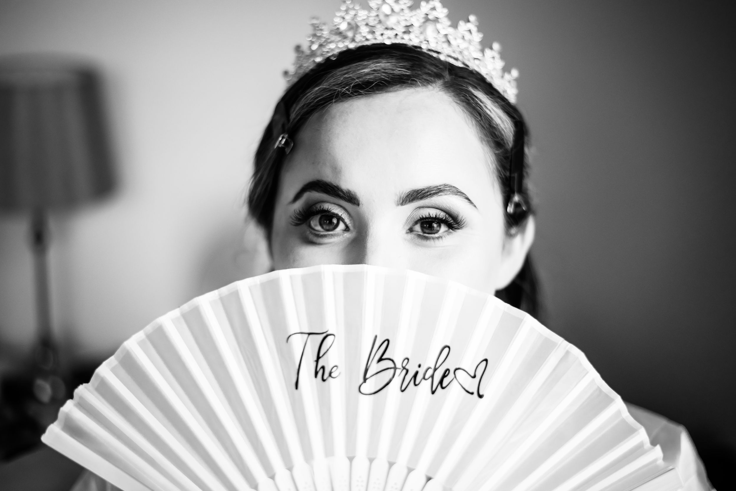 Black and white artistic wedding photography collage showing details of a tiara, paper fan, and bouquet arrangements.