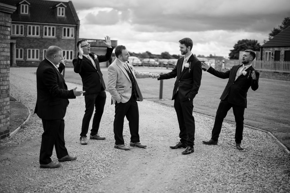 A group of formally dressed people having an animated discussion outdoors.