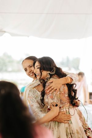 A joyful dancing couple embraces at a wedding reception under a white tent canopy.