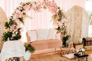 Elegant wedding venue decorated with soft pink and white floral arrangements on ornate cream-colored columns.