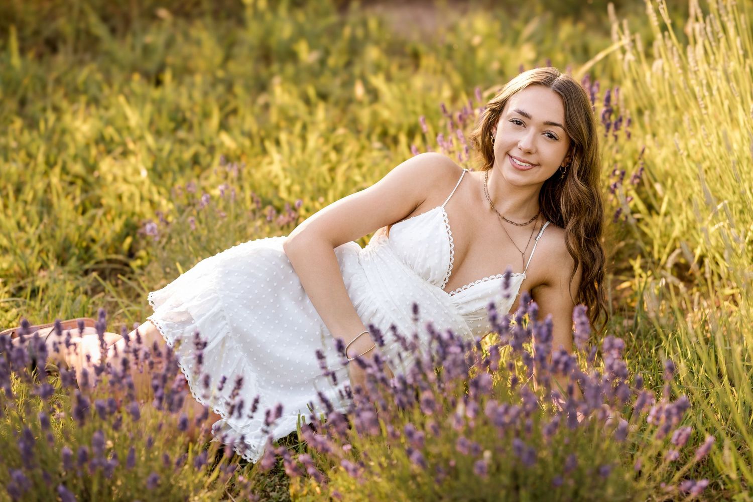 Portrait session in golden field with purple wildflowers during sunset.