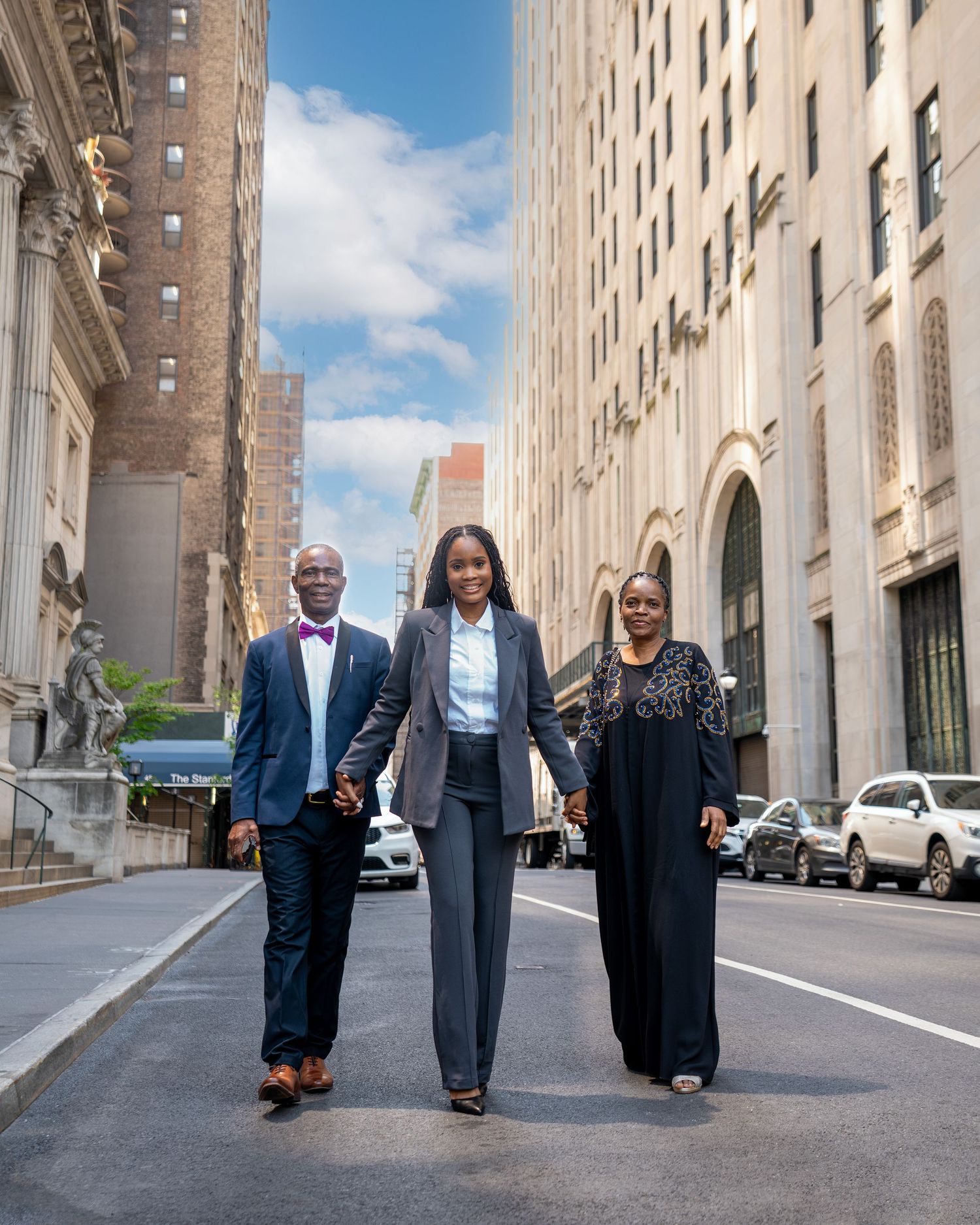 Professional group in business attire walking together on city street between tall buildings.
