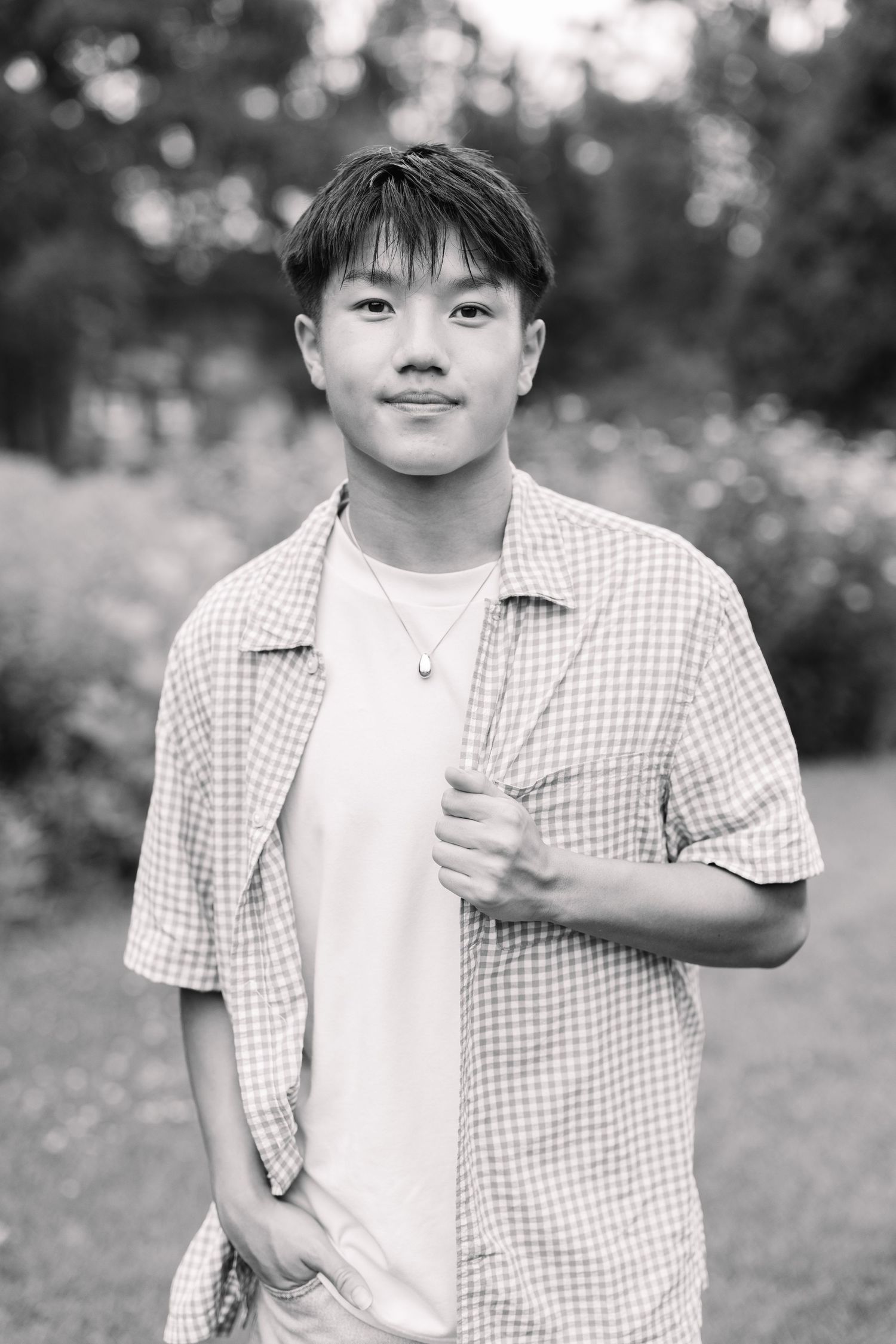 A black and white sequence of four photos shows a person wearing a checkered shirt and white t-shirt outdoors.