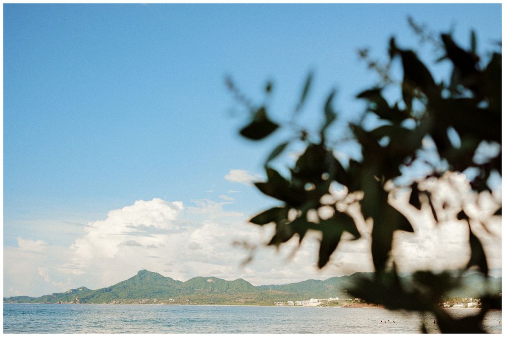 Rocky coastline with mountains and ocean under blue sky at Samui Island in Thailand.