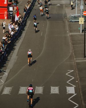 Aerial view of runners on a city street during a marathon race with spectators lining the course.