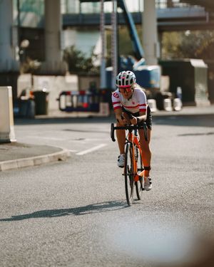 Cyclists riding in a line on an urban street with shallow depth of field creating a blurred motion effect.