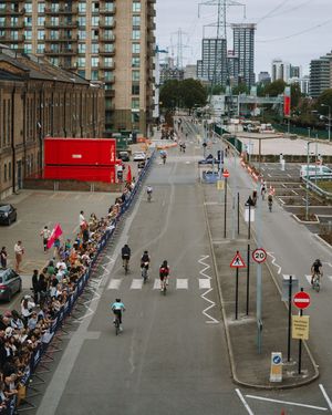 Aerial view of a city street with spectators lining the route for a cycling event.
