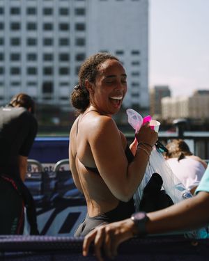 People gathered outdoors on a sunny day with city buildings visible in the background.