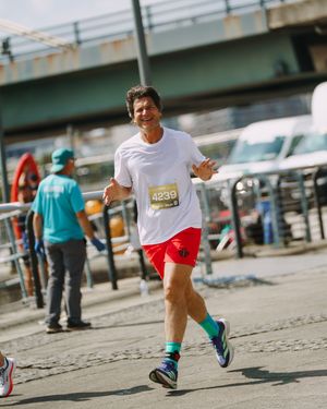 Runners' legs in motion on a paved surface during an athletic competition.