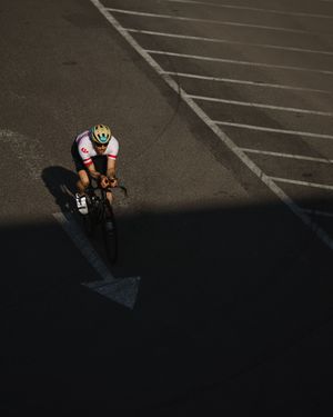 Aerial view of shadows cast by cyclists on an empty parking lot surface.
