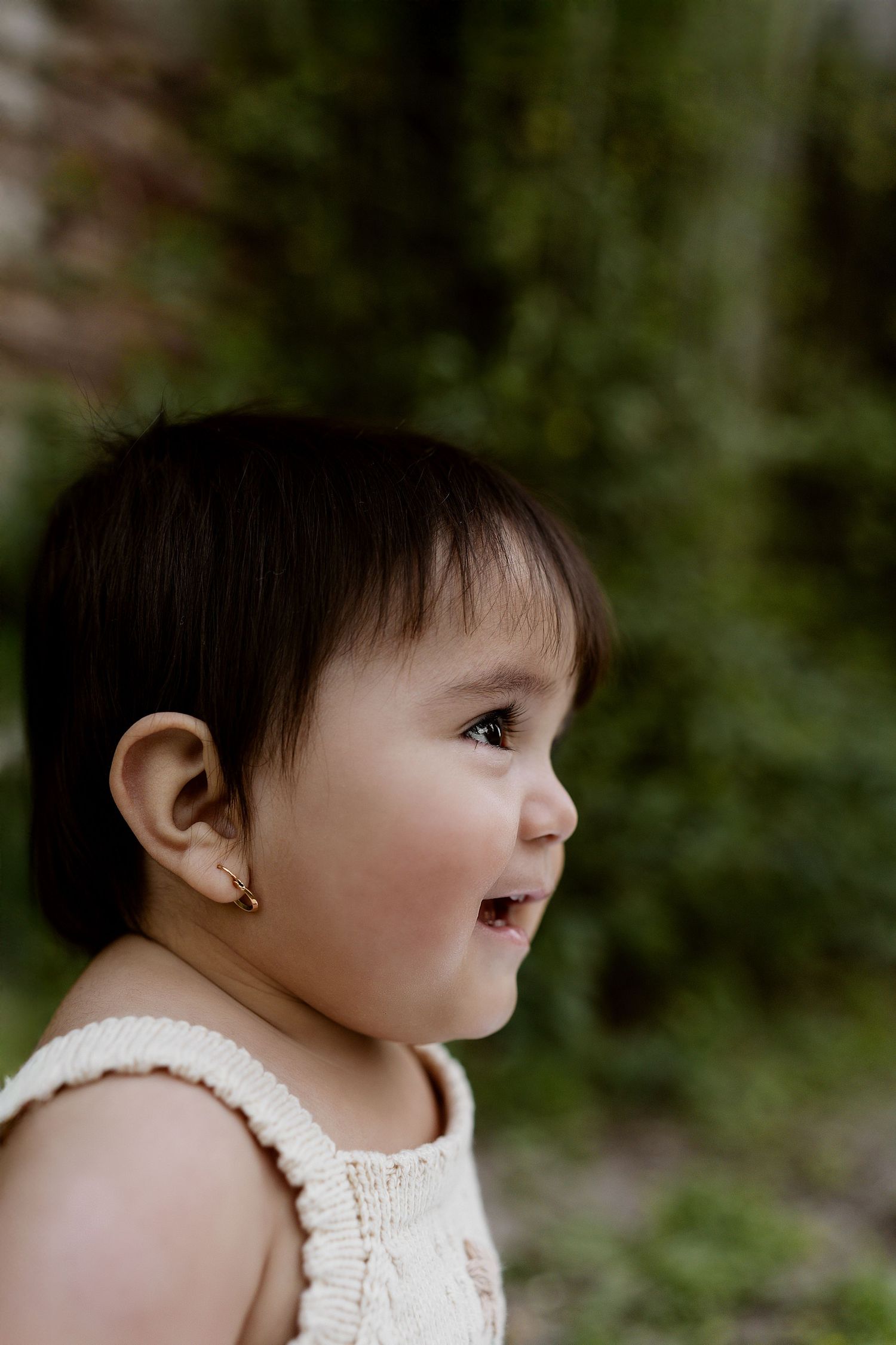 A sequence of cropped photos showing a small baby in white clothing looking sideways against a blurred background.