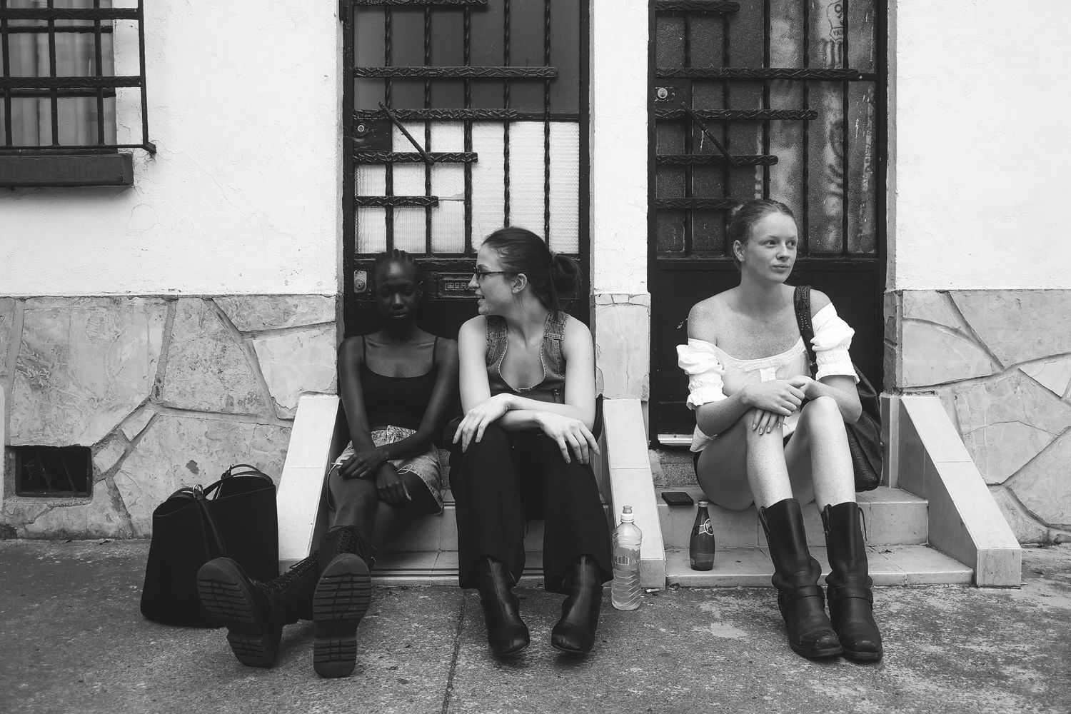 Black-and-white street portrait of three women seated | Editorial photography by Dario Hudon, Le Café Studio