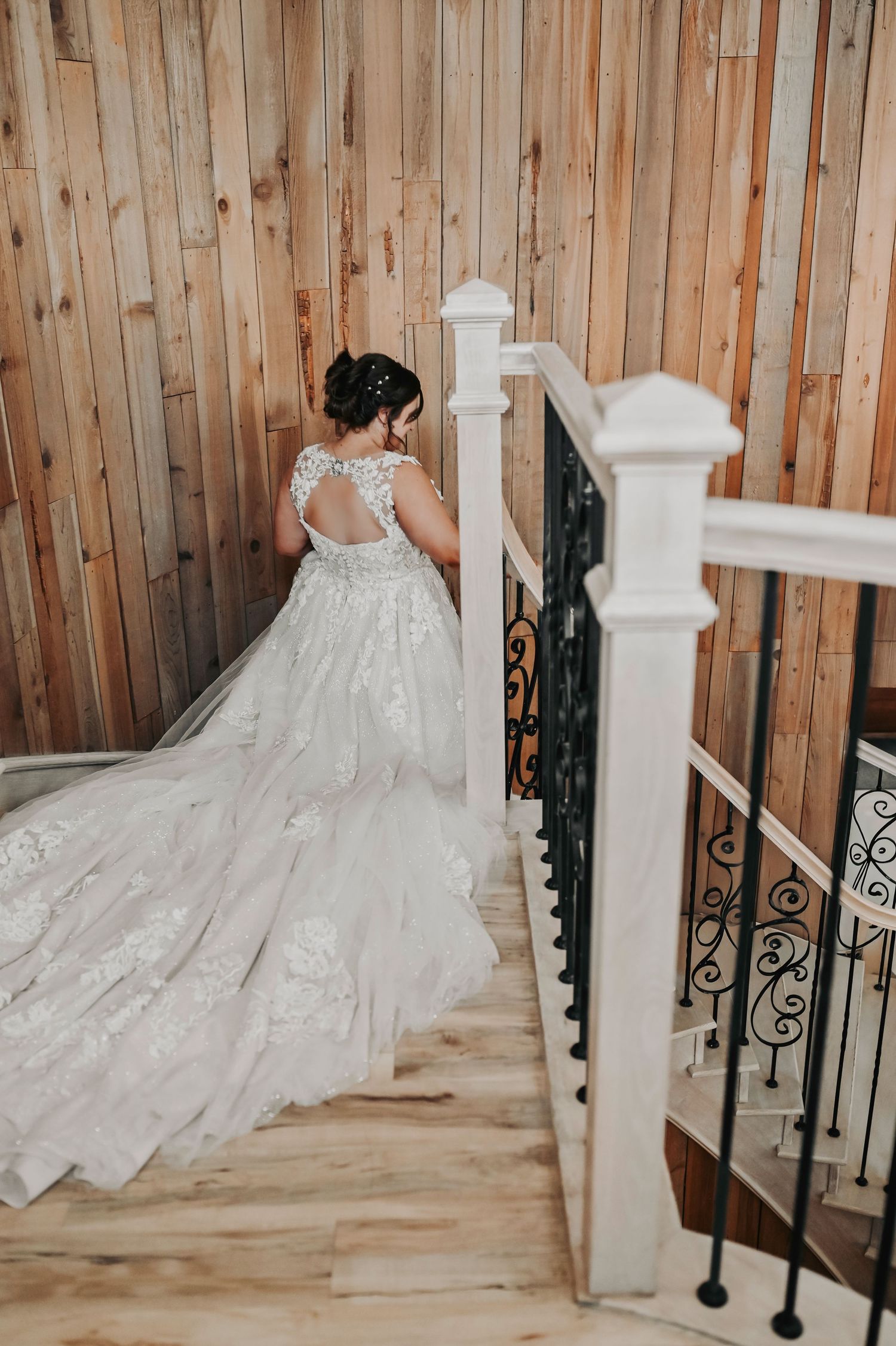 Bride walking down Whispering Oaks staircase for first look