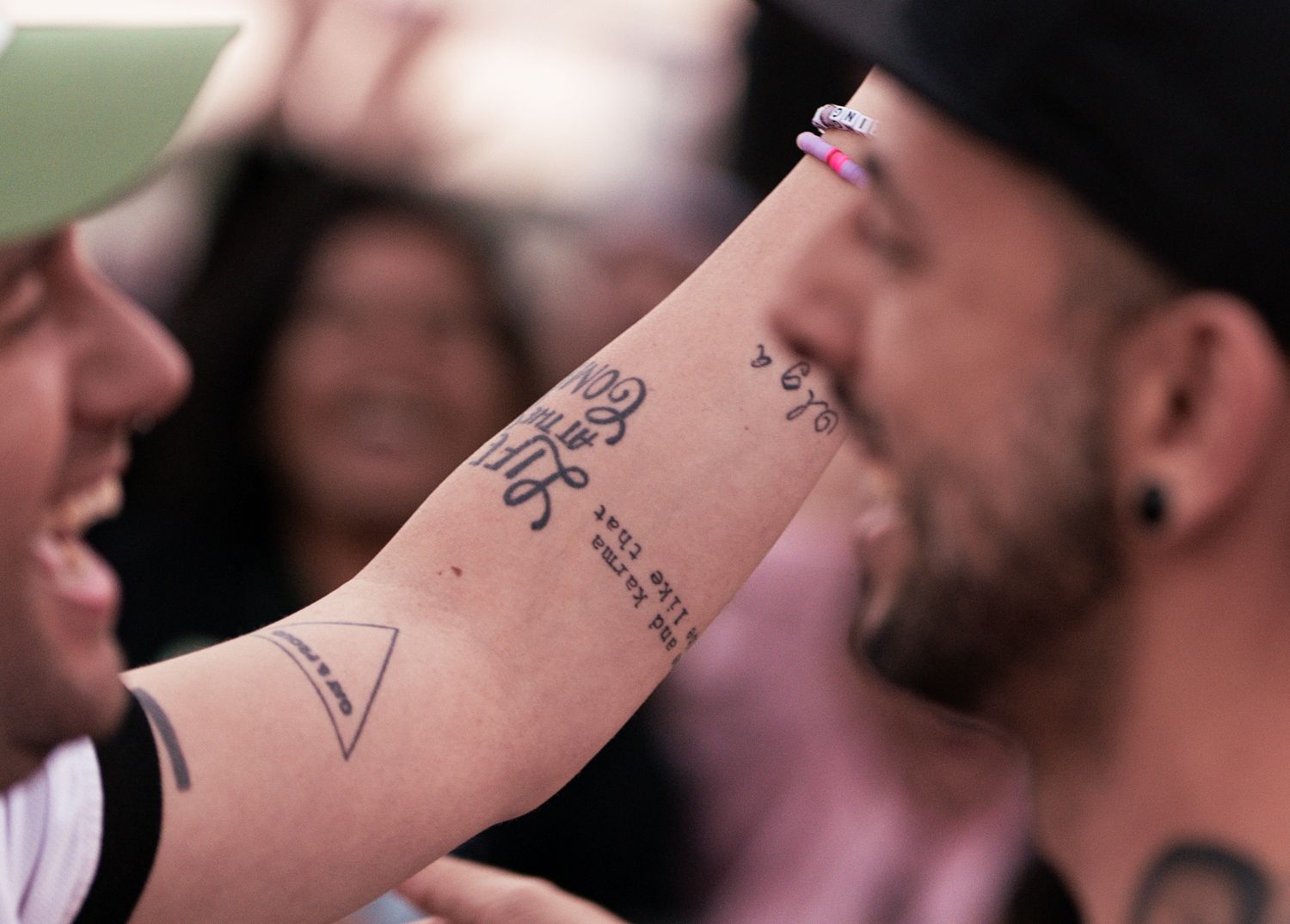Close-up shot of arm showing detailed tattoo artwork during a celebration.