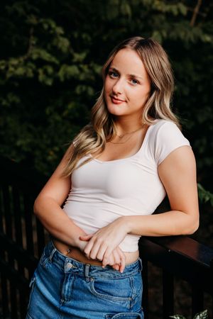 Woman in white t-shirt and blue jeans poses outdoors in a series of casual lifestyle photos.
